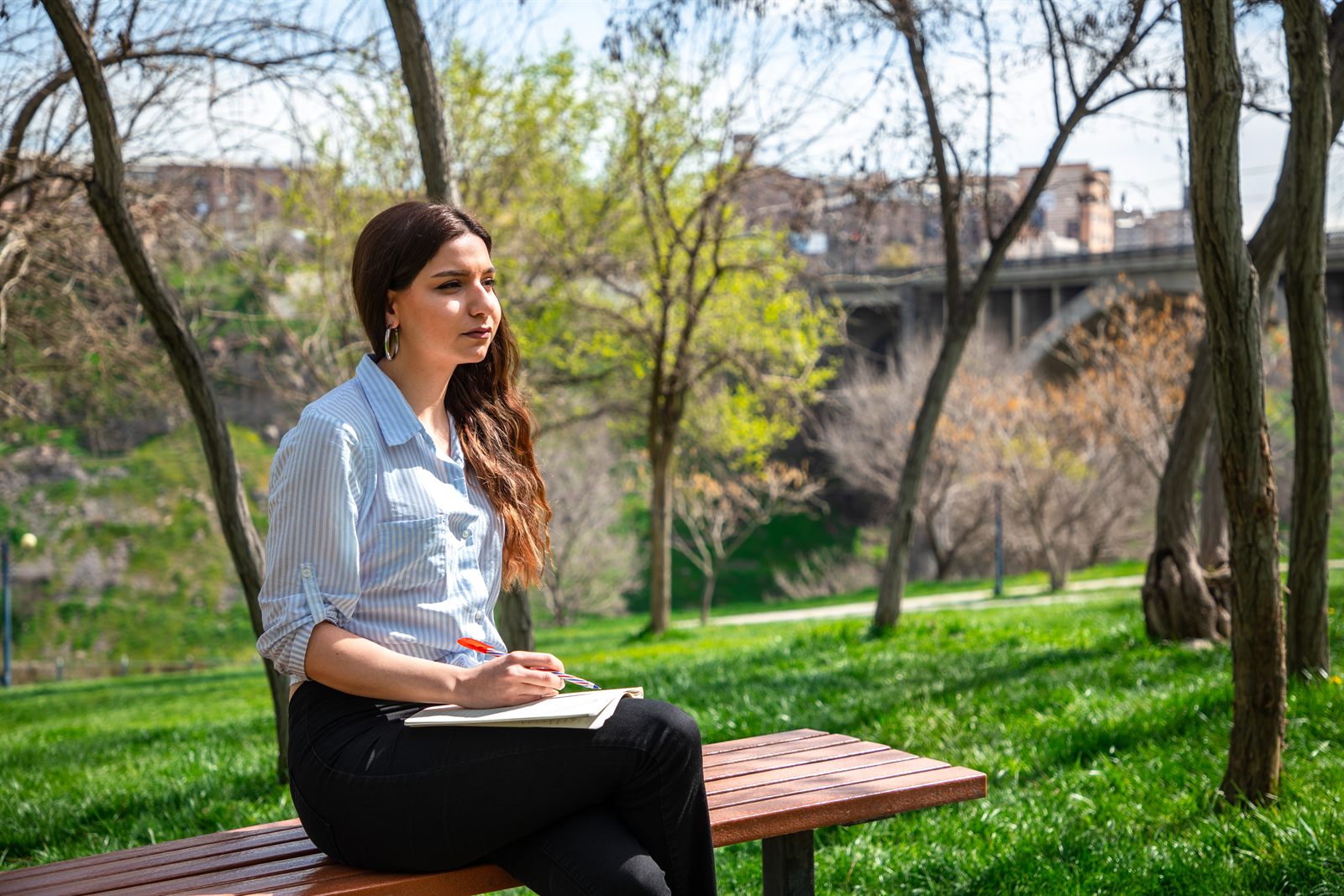 A social work student studying outdoors in a park